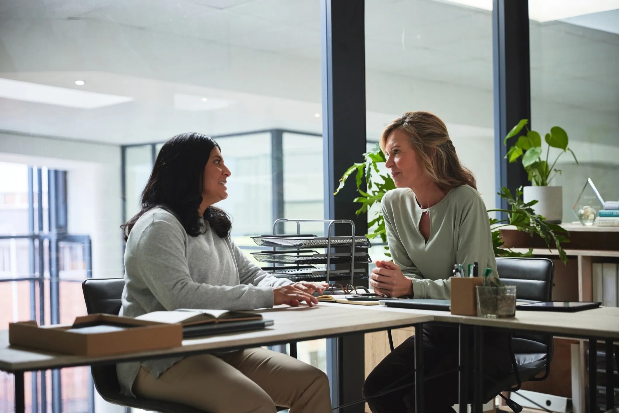 Professionals having a supportive conversation in a modern workplace